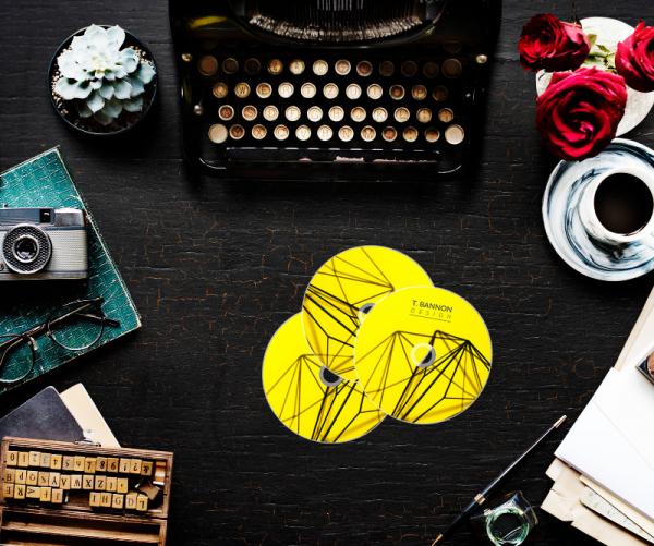 Discs next to a camera and glasses on a book, type writer and other miscellaneou