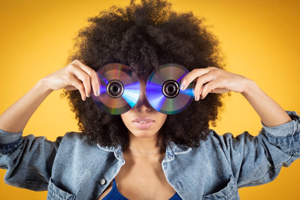 Person holding two CDs in front of their eyes